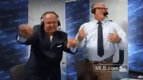 Two Men Wearing Headphones And Ties Are Dancing In Front Of A Mlb.com Sign . GIF