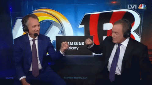 Two Men Wearing Headphones Are Sitting In Front Of A Screen That Says Samsung Galaxy GIF