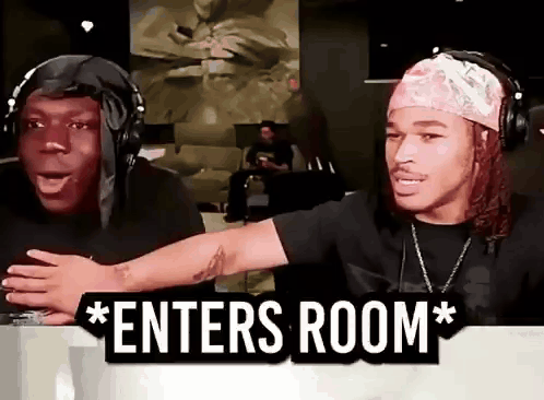 Two Men Wearing Headphones Are Sitting In Front Of A Sign That Says " Enters Room " . GIF