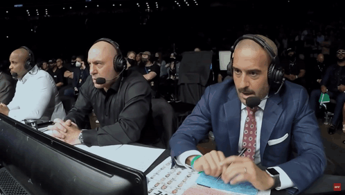 Two Men Wearing Headphones Sitting with UFC Sign