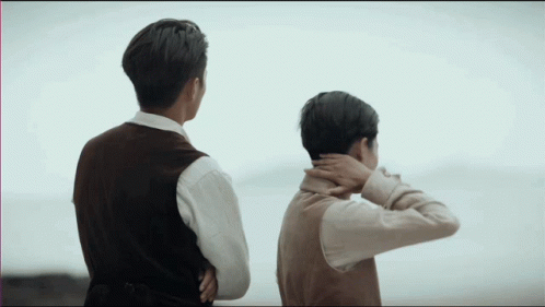 Two Men With Arms Crossed Looking At Ocean GIF