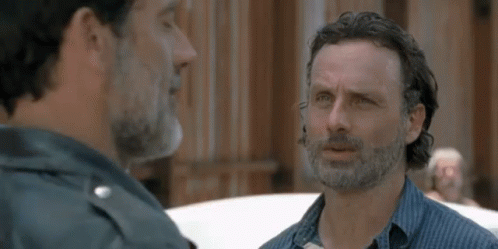 Two Men With Beards Are Talking To Each Other In Front Of A Building . GIF