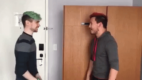 Two Men With Green Hair Are Standing Next To Each Other In A Room And Talking To Each Other . GIF