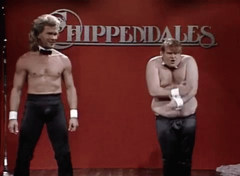 Two Men Without Shirts Are Standing Next To Each Other On A Stage In Front Of A Red Wall . GIF