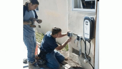 Two Men Working on Electrical Box