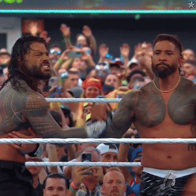 Two Men Wrestling In Front Of A Crowd With A Star On The Bottom Right GIF