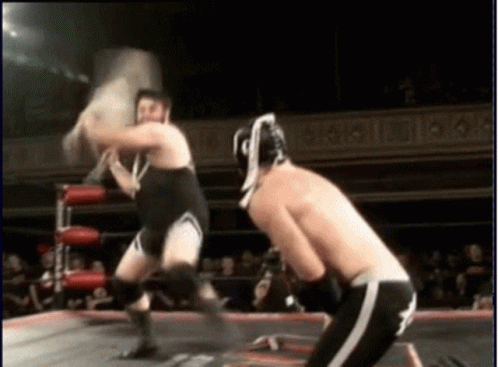 Two Men Wrestling in Ring Saying A