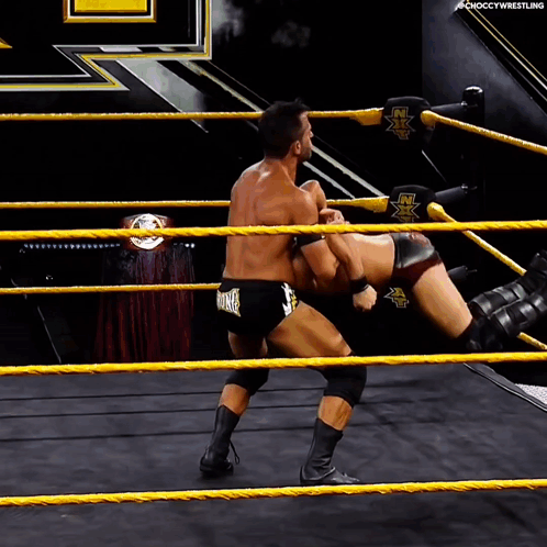 Two Men Wrestling in Ring Saying NX