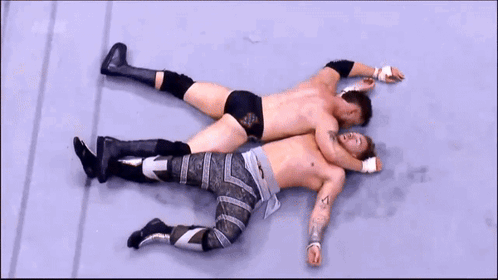 Two Men Wrestling in Ring with AEW Sign