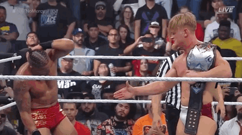 Two Men Wrestling in Ring With Championship Belt