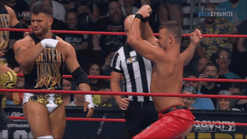 Two Men Wrestling in Ring With Dynamite