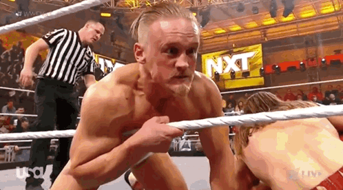 Two Men Wrestling in Ring With Referee