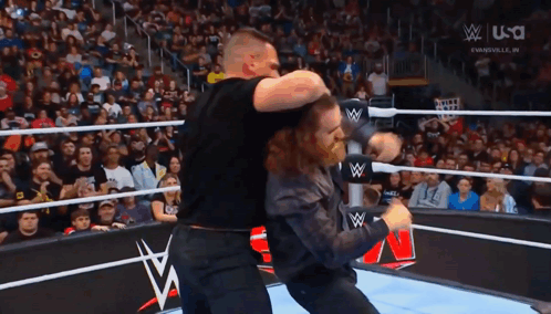 Two Men Wrestling in Ring With W