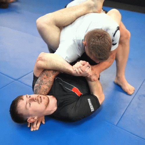 Two Men Wrestling on Blue Mat