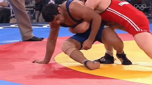 Two Men Wrestling On Mat, One With T Shirt