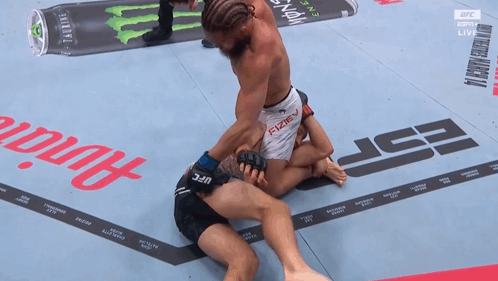 Two Men Wrestling on Mat With UFC