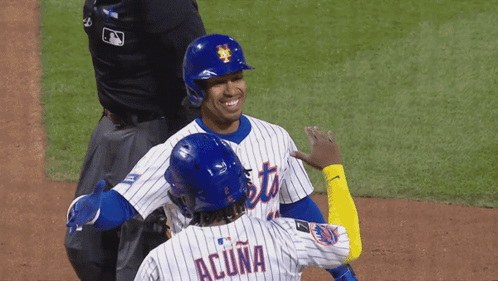 Two Mets Baseball Players Wearing Blue Helmets Are Smiling GIF