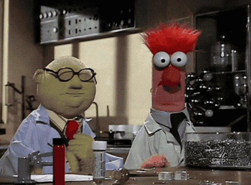 Two Muppets Are Standing Next To Each Other In A Lab And One Has Glasses On GIF