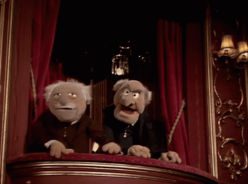 Two Muppets Sitting on Balcony in Dark Room