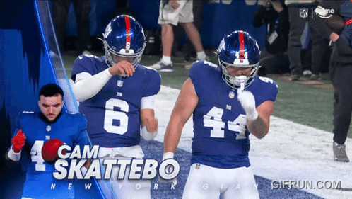 Two New York Giants Football Players Are Standing On A Field GIF