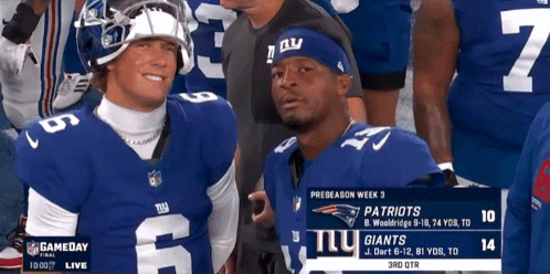 Two New York Giants Players Are Standing Next To Each Other During A Game GIF