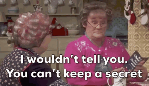 Two Older Women Are Sitting At A Table In A Kitchen Talking To Each Other And One Of Them Is Holding A Book . GIF