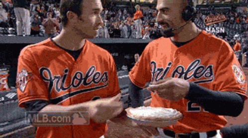 Two Orioles Baseball Players Holding A Pie GIF