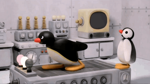 Two Penguins Standing Next to TV