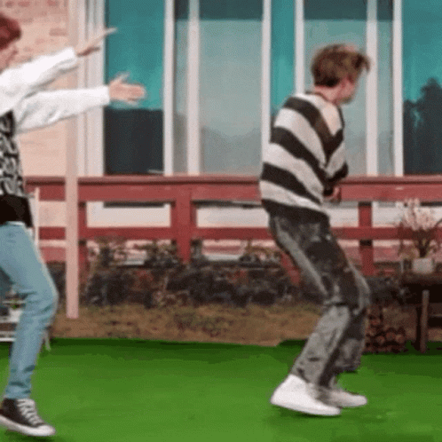 Two People Are Dancing On A Green Field . GIF