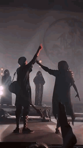 Two People Are Dancing On A Stage In A Dark Room . GIF
