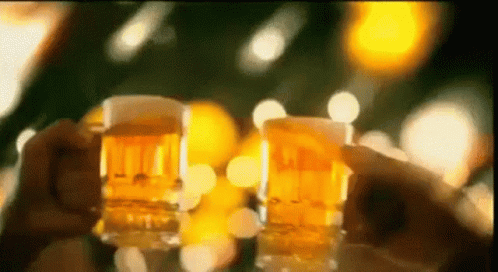 Two People Are Holding Glasses Of Beer In Their Hands . GIF