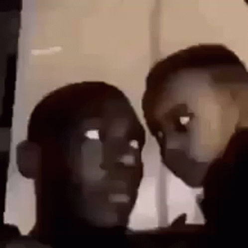 Two People Are Looking At Each Other Through A Window . GIF