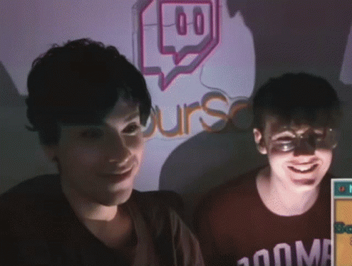 Two People Are Smiling In Front Of A Sign That Says Urs GIF