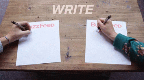 Two People Are Writing On A Wooden Table With The Words Write Buzzfeed And Buzzed GIF