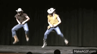 Two People In Cowboy Hats Are Jumping In The Air On Stage GIF