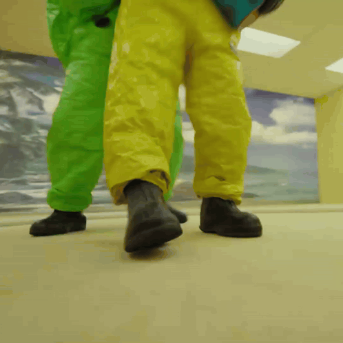 Two People in Green and Yellow Suits Walking