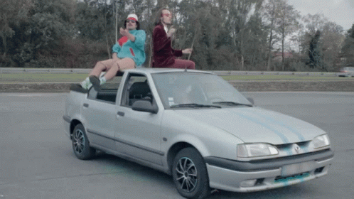 Two People On Silver Car With A License Plate GIF
