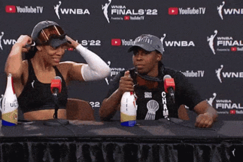 Two People Sitting At A Table In Front Of A Wall That Says Youtubetv GIF