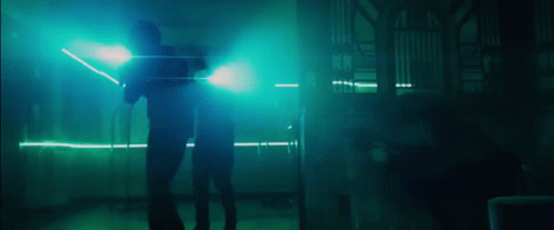 two people standing in a dark room with blue lights