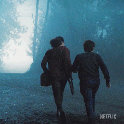 Two People Walking Through Foggy Forest GIF