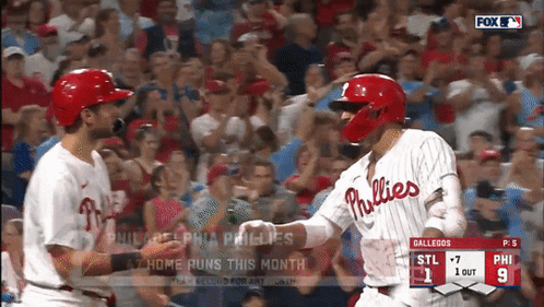 two phillies players shake hands during a game