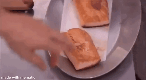 Two Pieces Of Bread Are Sitting On A Plate On A Table . GIF