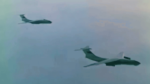two planes are flying in the sky and one is flying towards the other .