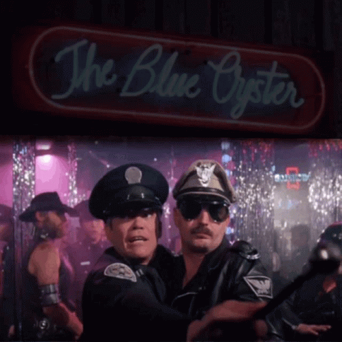 Two Police Officers Are Standing In Front Of A Neon Sign That Says The Blue Oyster GIF