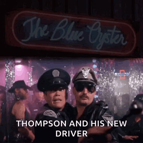 Two Police Officers Standing In Front Of The Blue Oyster GIF