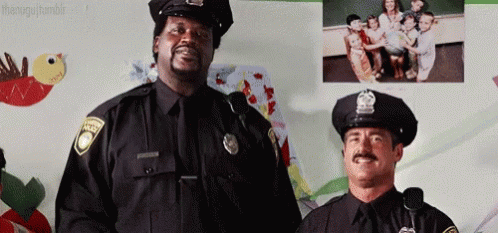 Two Police Officers Standing Next to Wall of Children