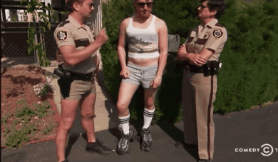Two Police Officers Talking To A Man In Shorts And Socks GIF