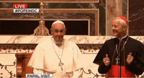 Two Priests Are Standing In Front Of A Live Papal Visit Screen GIF
