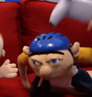 Two Puppets on Red Couch, One With Blue Helmet