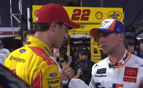 Two Race Car Drivers Are Shaking Hands In Front Of A Pennzoil Sign GIF